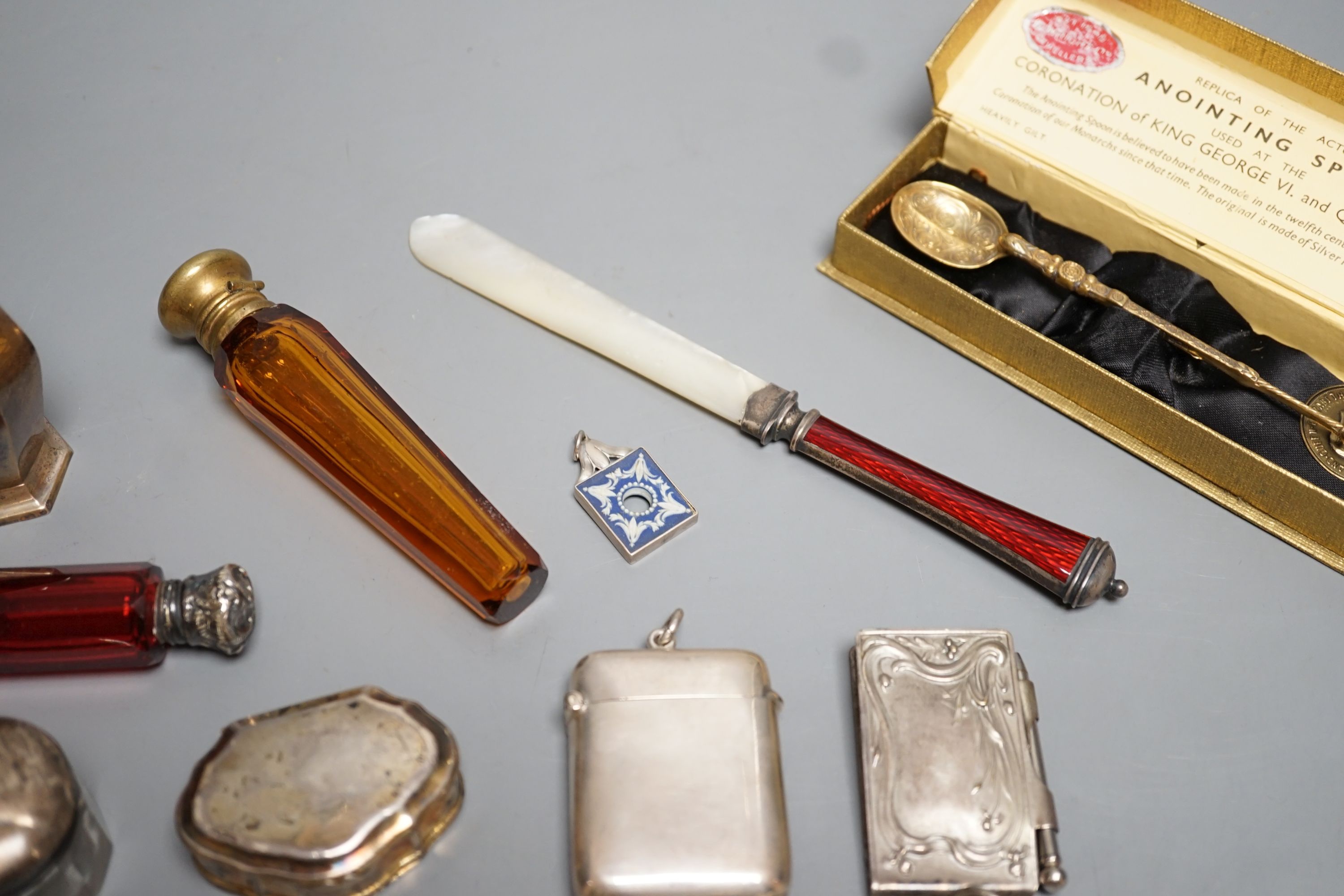 Four assorted white of gilt metal mounted glass scent bottles, largest 12.2cm, an unusual gilt white metal snuff box?, with spoon, a sterling and enamel mounted mother of pearl paper knife and other minor items.